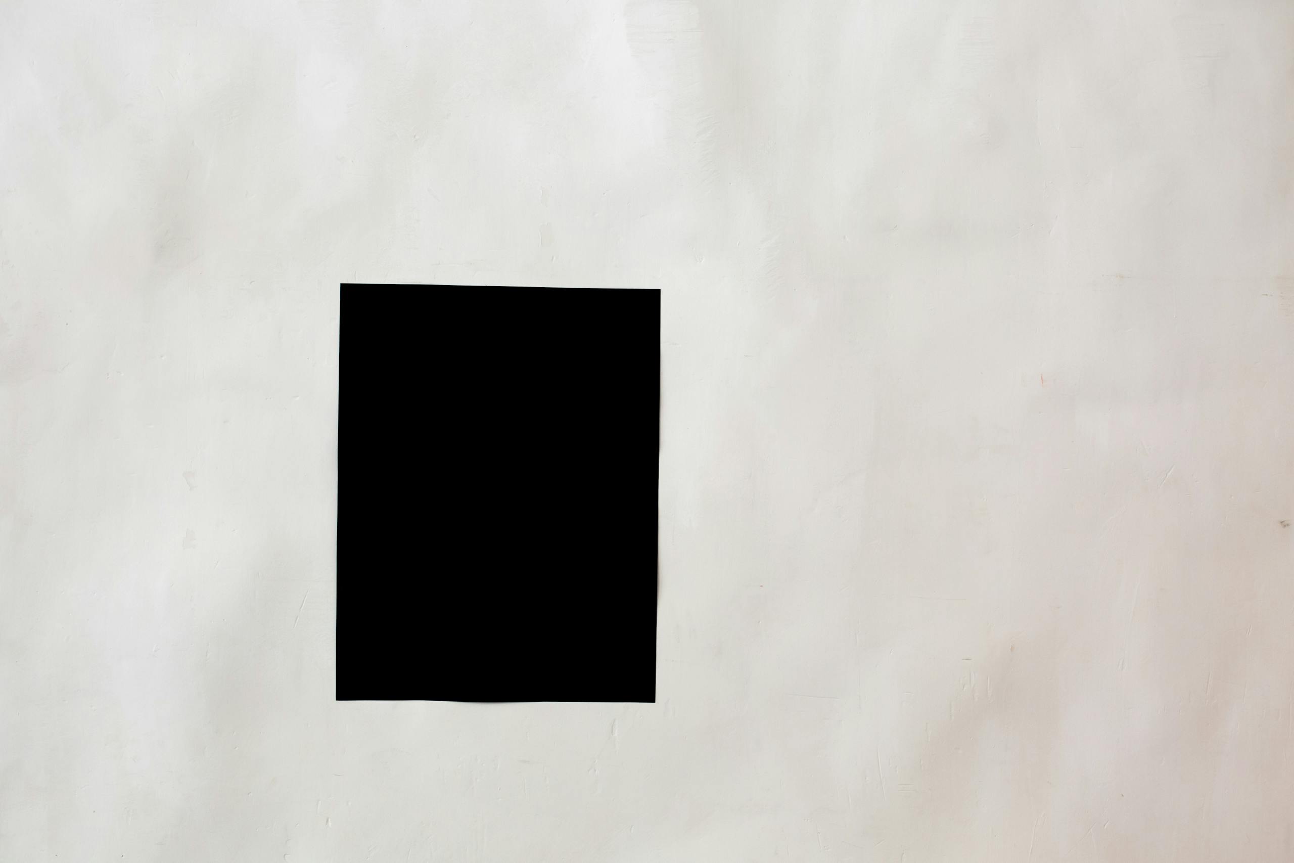 Creative black mock up rectangular paper sheet with copy space attached on white wall in light room of modern studio